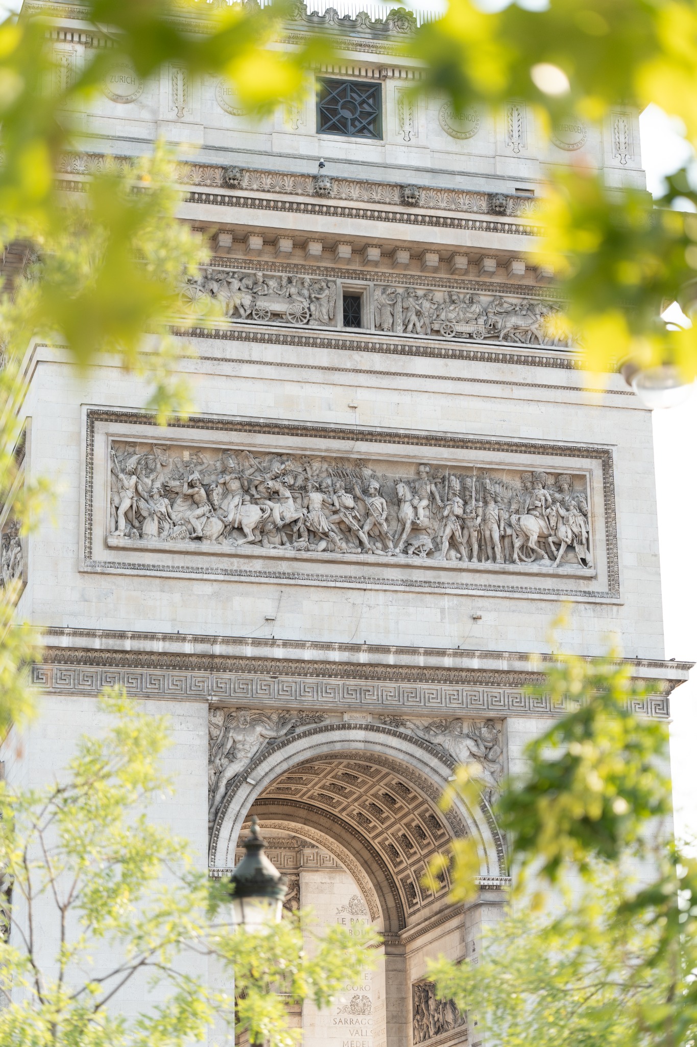 The Arc de Triomphe framed through green leaves