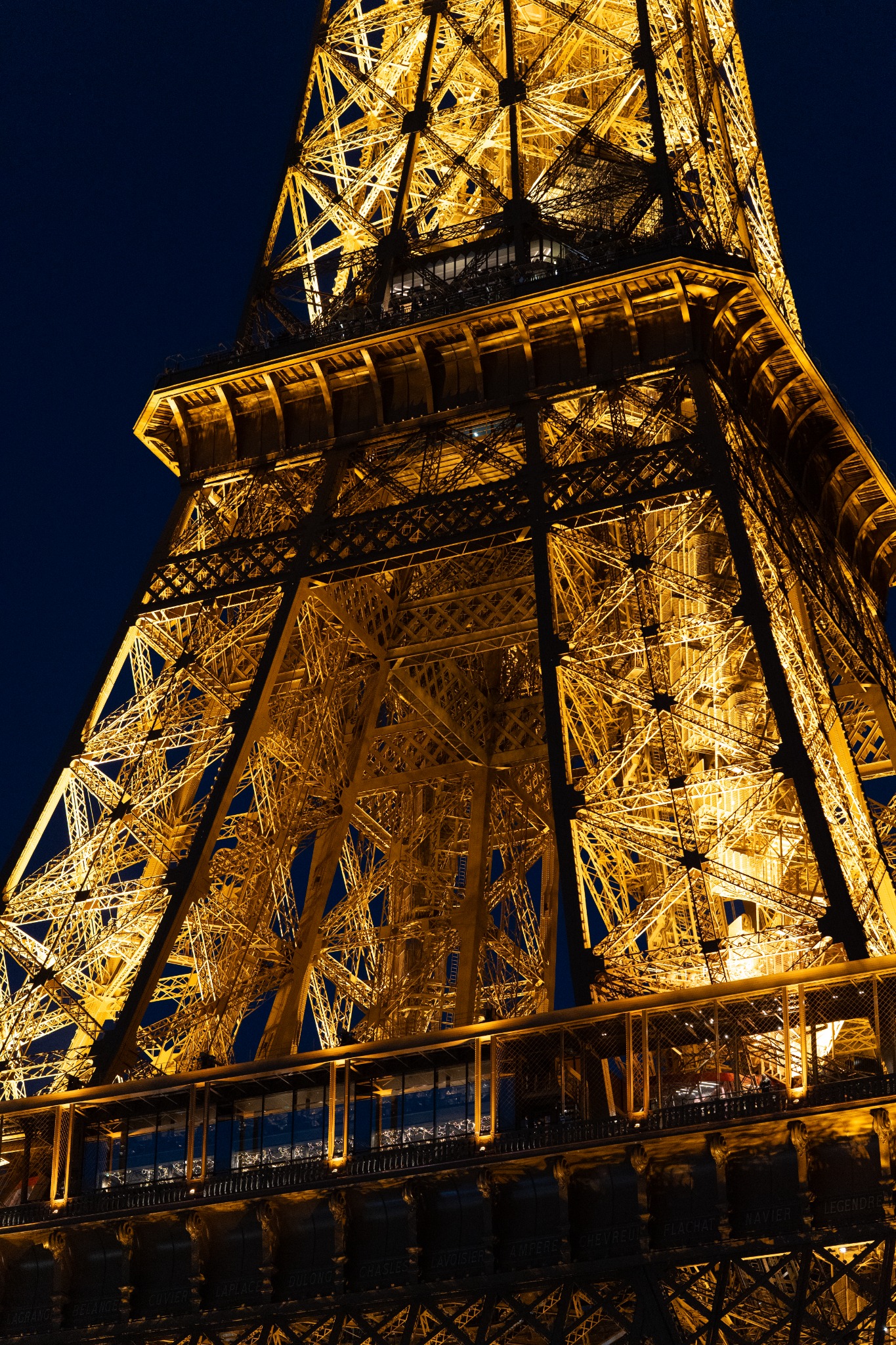 Close view of the Eiffel Tower glowing against the night sky