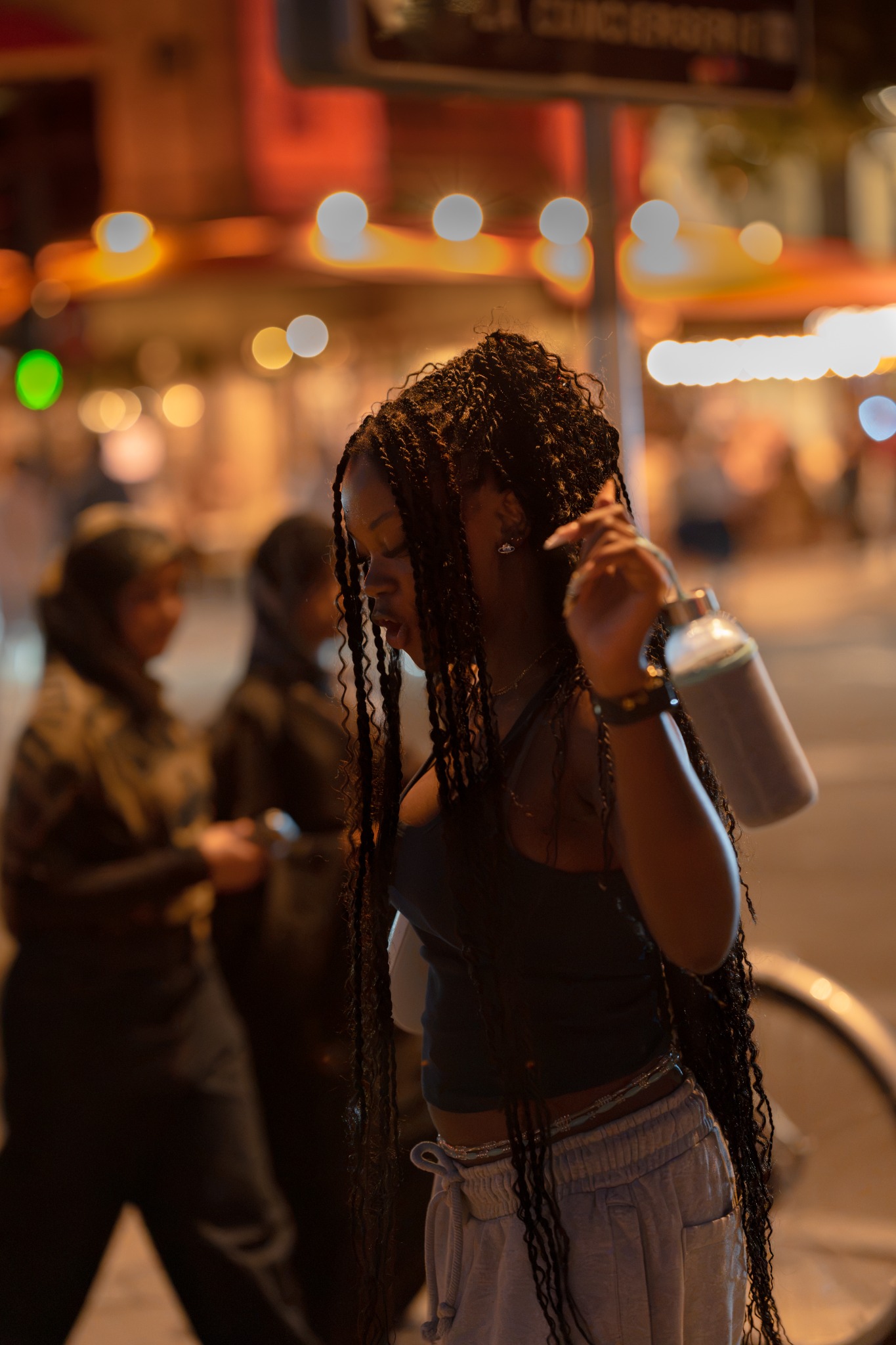 Woman dancing beneath warm city lights