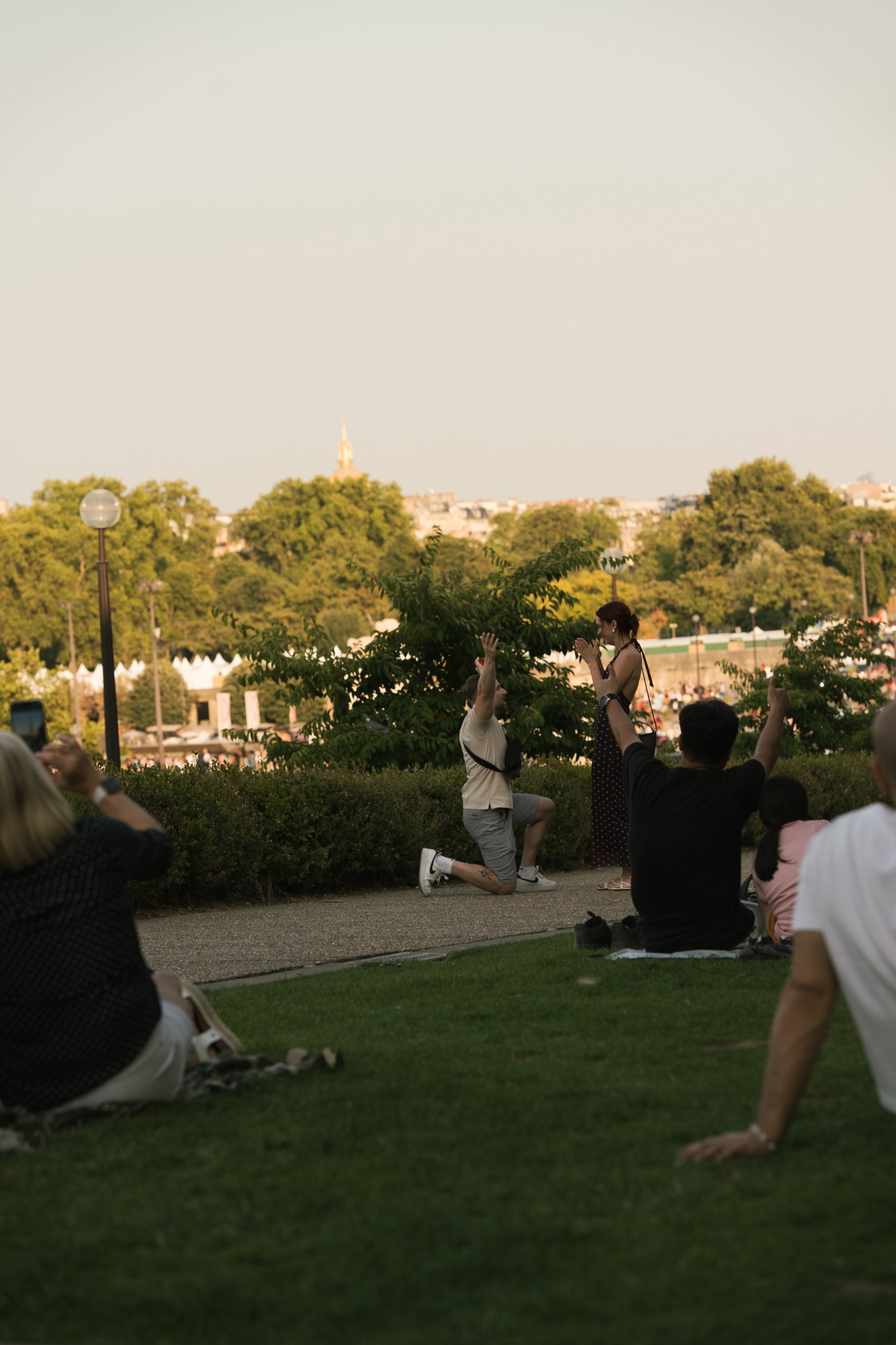 A woman reacting to a marriage proposal in a Paris garden