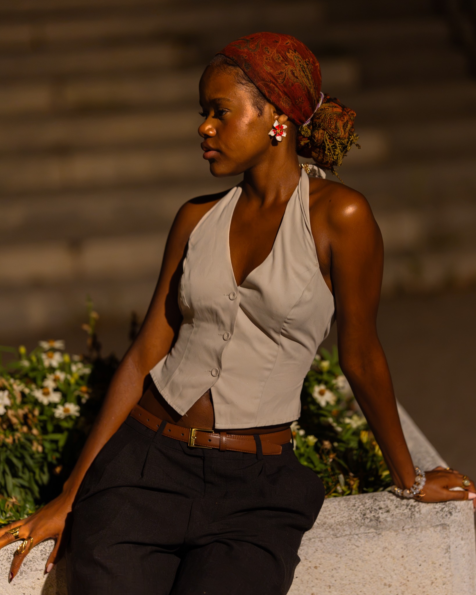Woman in profile seated beside flowers at night